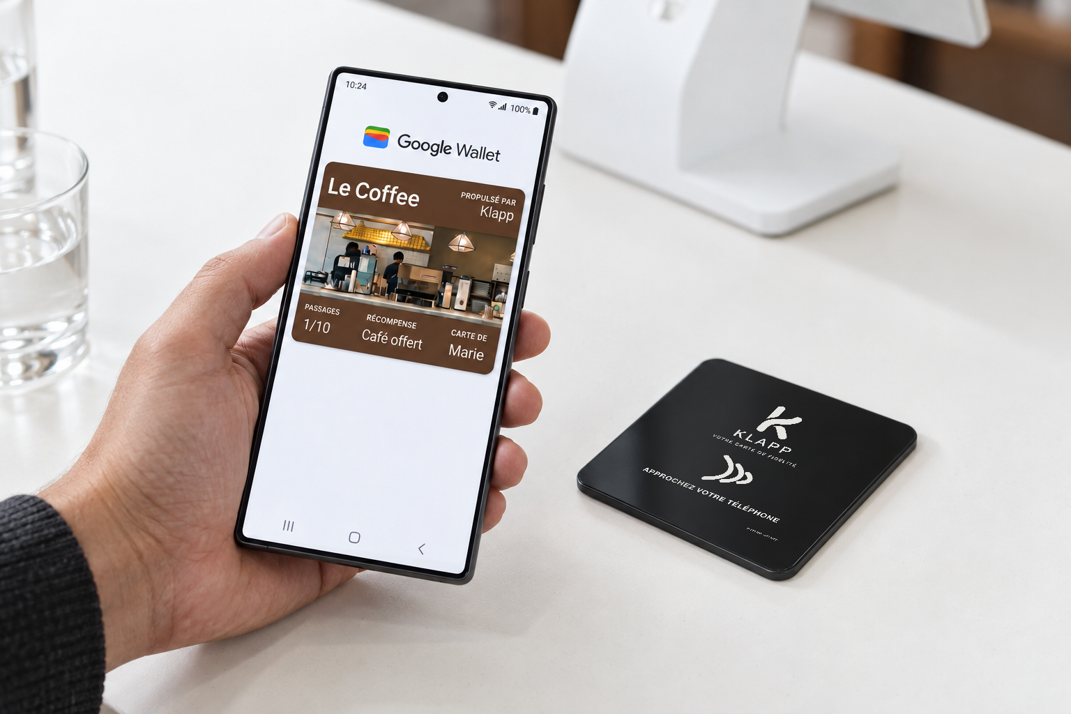 A customer shows a loyalty card in Google Wallet beside the Klapp stand on the counter.
